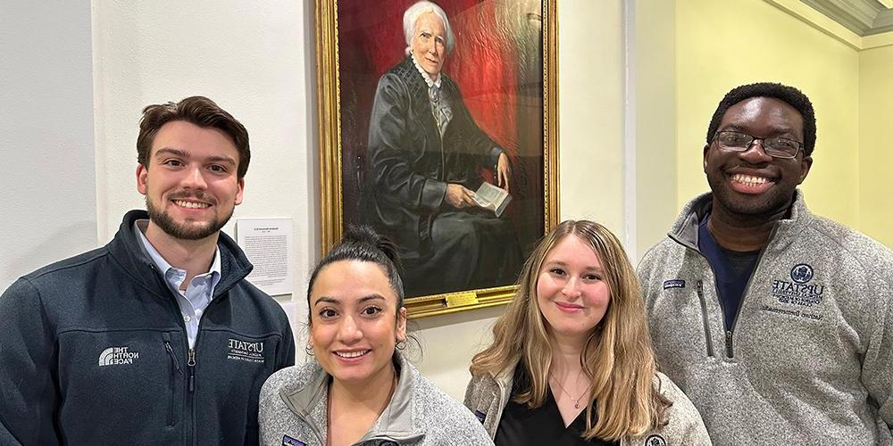 Presidents of the classes of the Norton College of Medicine gather by the portrait of Blackwell. From left: Nathan Ihemeremadu, Gavrielle J. Rood, Katherine Narvaez Mena and Christopher Bushnell. 